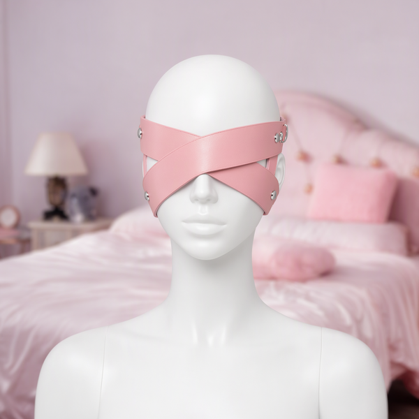 Blind Date cross strap eye mask in pink, front view on a mannequin, two straps crossing over the eyes