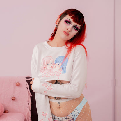 Person wearing a white long-sleeve shirt with cartoon designs and light blue underwear against a pink background.