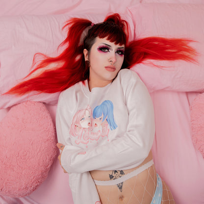 Person wearing a white sweatshirt with cartoon characters on a pink background