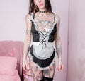 Person wearing a black and white lace maid outfit with tattoos visible.