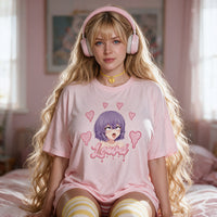 Lewd Otaku pink oversized shirt — kneeling on the bed with the print flat to camera