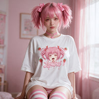Strawberry Ahegao white oversized shirt — kneeling on the bed with the print flat to camera