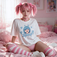 Model kneeling on pink bedding in the oversized tee with pink and white striped thigh high socks