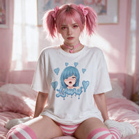 Pink twin-tailed model sitting on a pink bed in the white Brainrot Babe oversized tee, blue anime print centred on the chest