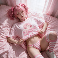 Lying back on pink bedding lifting the hem of the pink oversized shirt