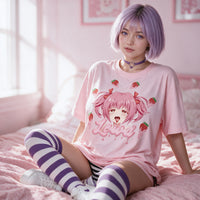 Strawberry Ahegao pink oversized shirt — seated on a pink bed with striped thigh highs