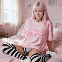 Drippy Bubble Pink Oversized Shirt — seated on pink bedding, the print on show