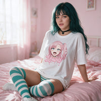 Model sitting on a pink bed in the white Ahegao Delulu oversized shirt with teal striped socks
